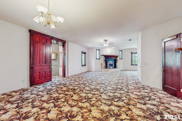 foyer entrance featuring carpet and ceiling fan with notable chandelier