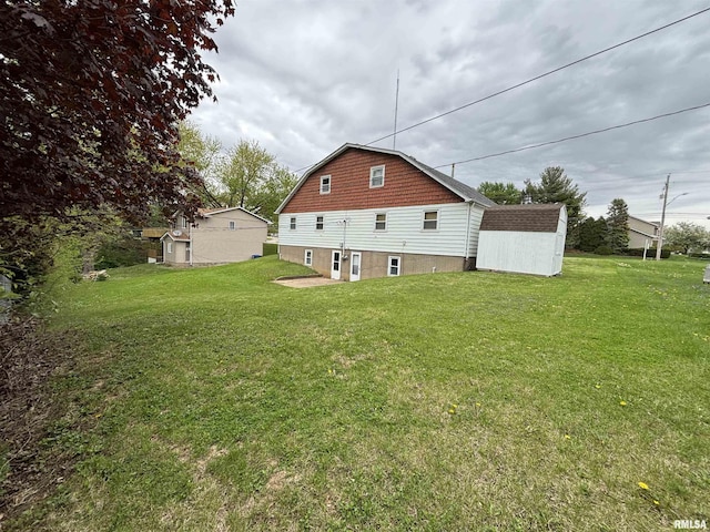 back of house featuring a lawn, an outbuilding, and a shed