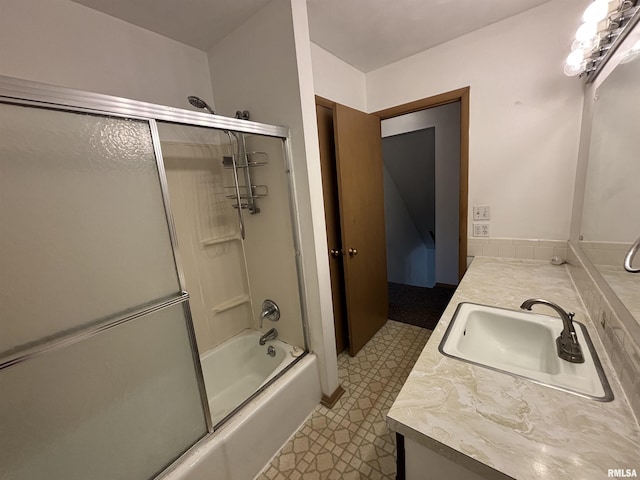 bathroom featuring vanity and shower / bath combination with glass door