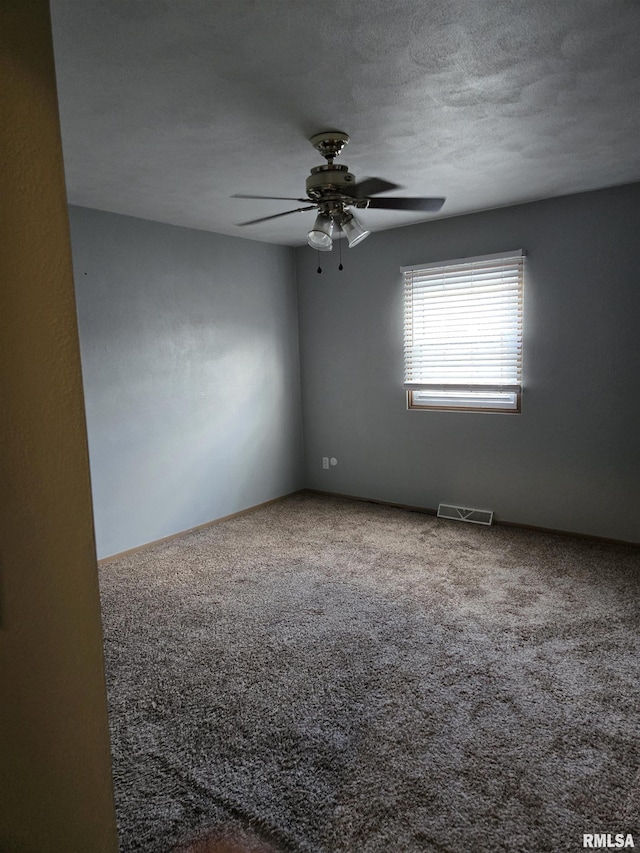 unfurnished room featuring carpet, a ceiling fan, and visible vents