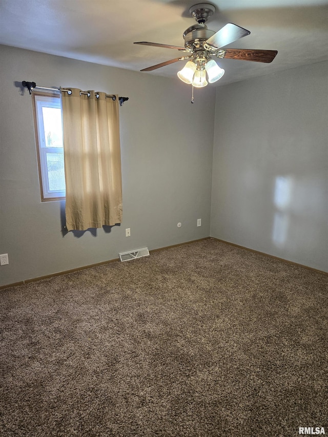 spare room with carpet floors, baseboards, a ceiling fan, and visible vents