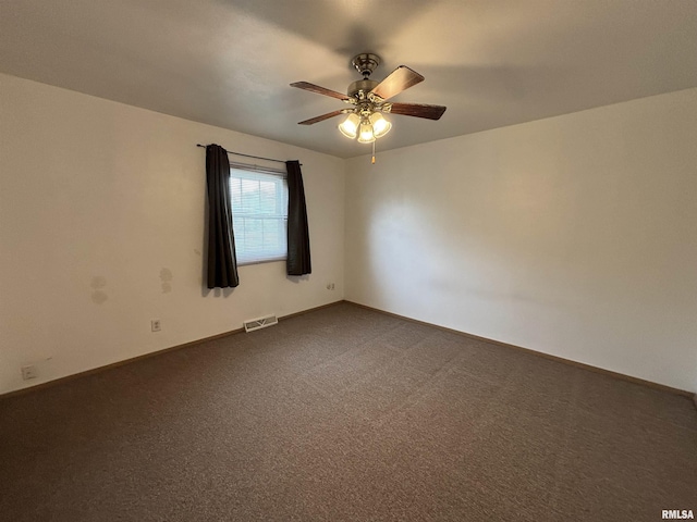 unfurnished room with a ceiling fan, baseboards, visible vents, and dark carpet