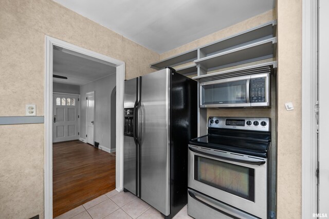 kitchen with stainless steel appliances and light tile patterned flooring