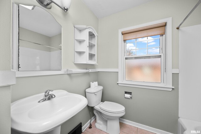 bathroom with tile patterned flooring, a sink, walk in shower, and toilet