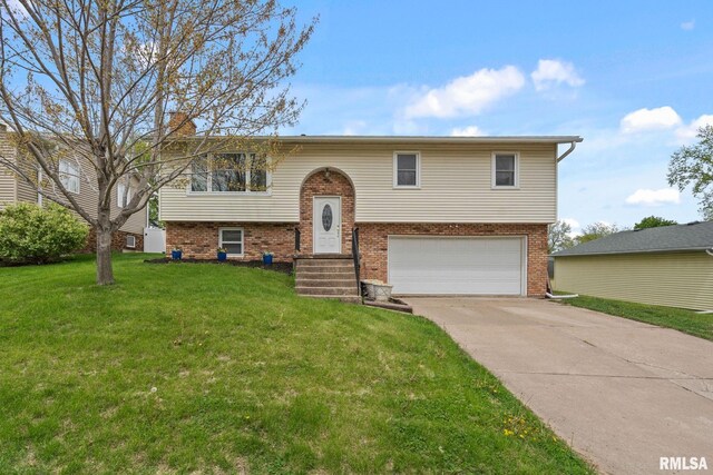 raised ranch with concrete driveway, brick siding, a front yard, and a garage