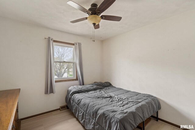 bedroom featuring baseboards, visible vents, ceiling fan, and light wood-type flooring