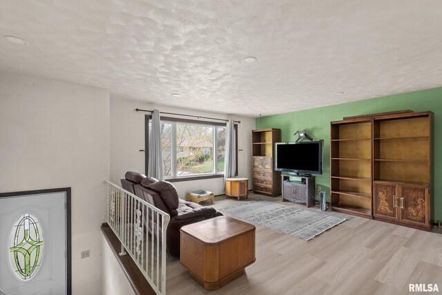living area featuring a textured ceiling and wood finished floors