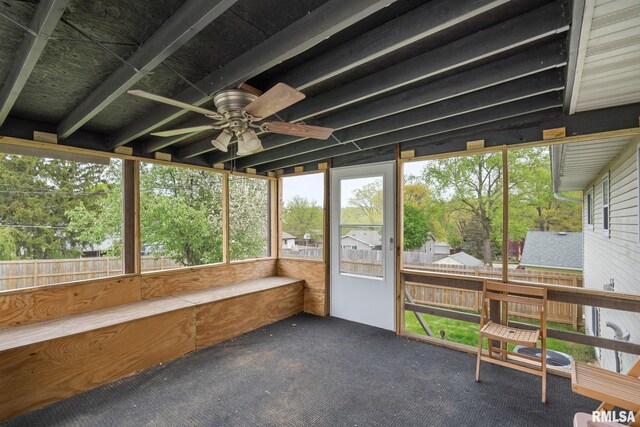 unfurnished sunroom featuring a ceiling fan