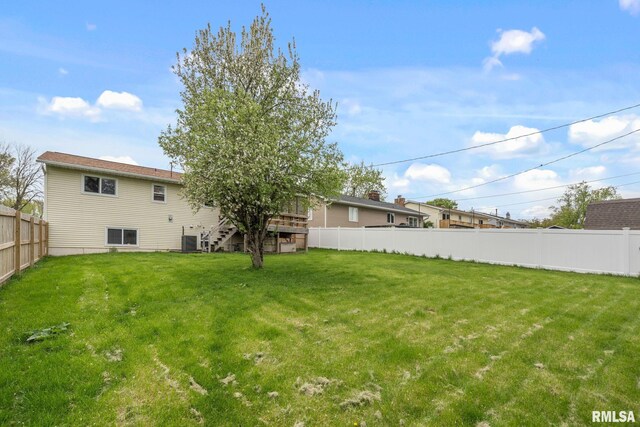 view of yard featuring a deck, fence private yard, and stairway