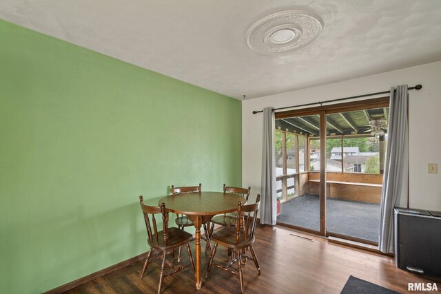 dining space featuring baseboards, visible vents, and wood finished floors