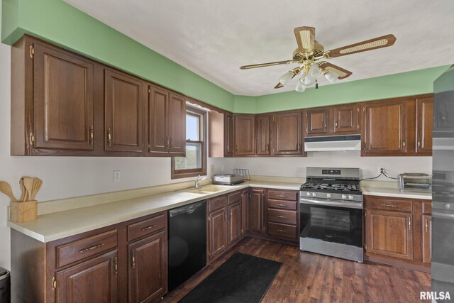 kitchen with a sink, dishwasher, gas range, under cabinet range hood, and dark wood-style floors