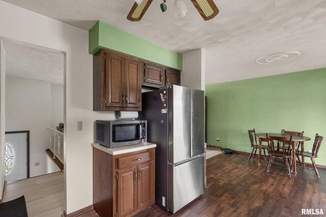 kitchen featuring ceiling fan, light countertops, dark wood finished floors, stainless steel appliances, and baseboards