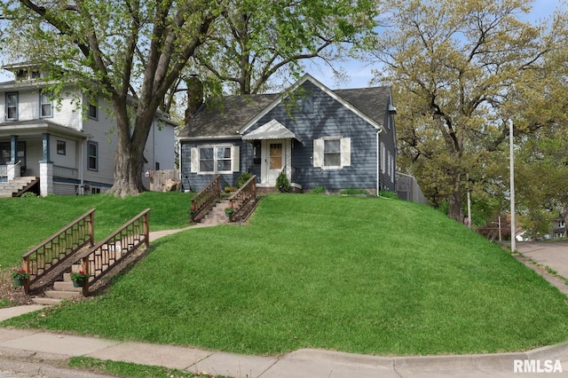 view of front facade featuring stairway, a chimney, and a front lawn
