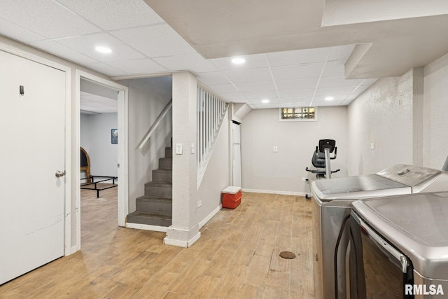 washroom featuring washer and dryer, laundry area, baseboards, and light wood-style floors