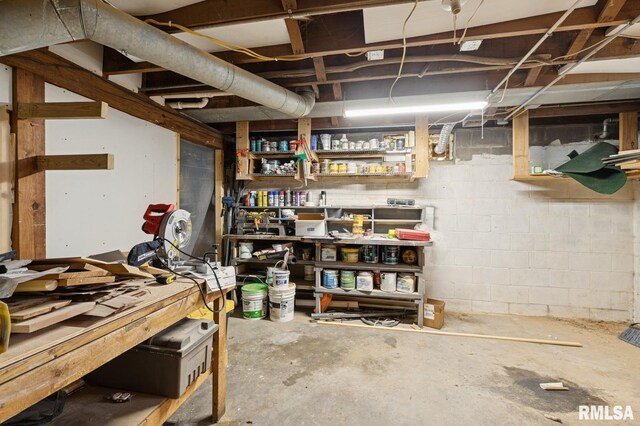 unfinished basement with concrete block wall and a workshop area