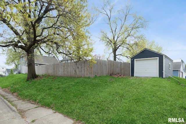 view of yard featuring fence, an outbuilding, and a detached garage