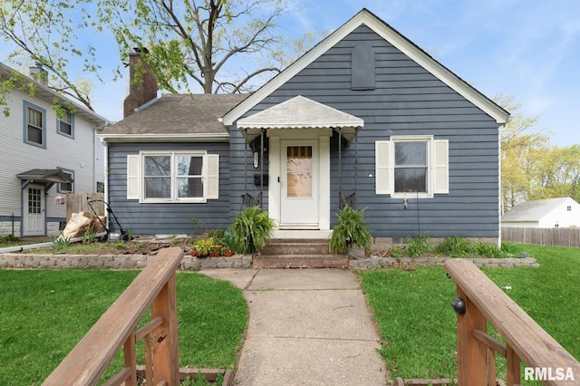 bungalow-style house featuring a front lawn, fence, a chimney, a shingled roof, and crawl space