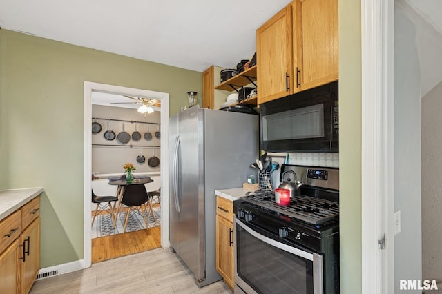 kitchen with decorative backsplash, light wood-type flooring, light countertops, a ceiling fan, and stainless steel appliances