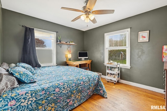 bedroom with a ceiling fan, baseboards, and wood finished floors