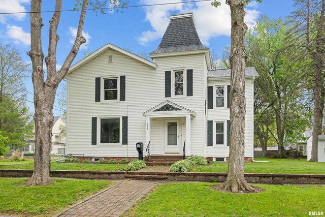 view of front of property featuring a shingled roof and a front yard