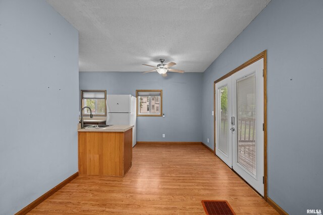 interior space with a sink, a wealth of natural light, freestanding refrigerator, and visible vents