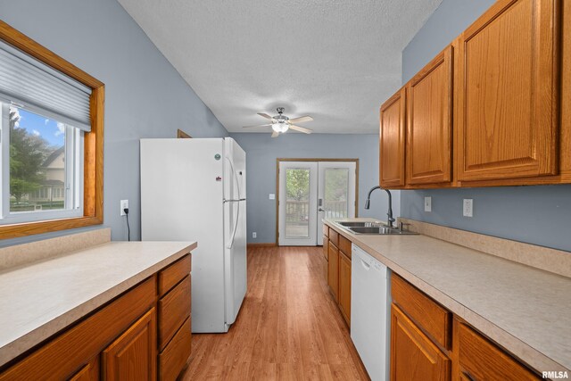 kitchen with white appliances, ceiling fan, light wood-type flooring, light countertops, and a sink