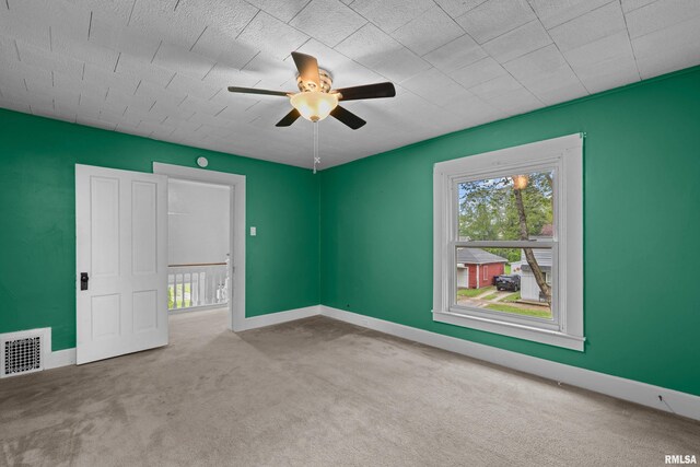 unfurnished bedroom featuring carpet floors, multiple windows, and visible vents