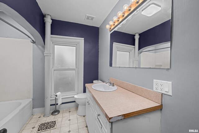 bathroom featuring visible vents, vanity, toilet, baseboards, and a bathtub