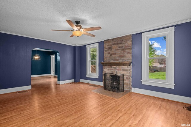 unfurnished living room with visible vents, wood finished floors, baseboards, a textured ceiling, and a ceiling fan