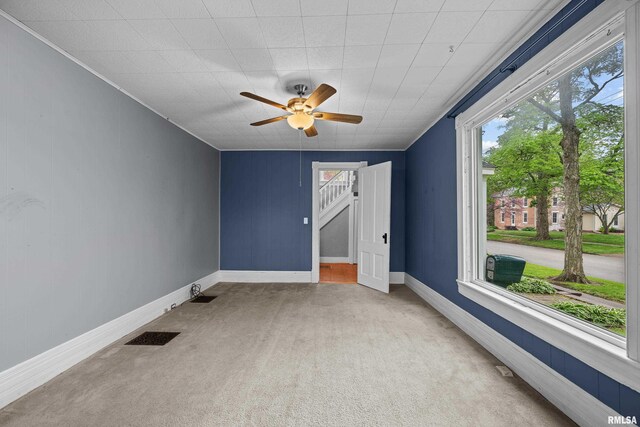 unfurnished bedroom with baseboards, multiple windows, carpet flooring, and ceiling fan