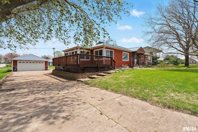 view of side of property with a lawn, a deck, an outbuilding, and a garage
