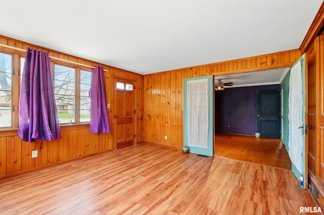interior space featuring baseboards, wood walls, and wood finished floors
