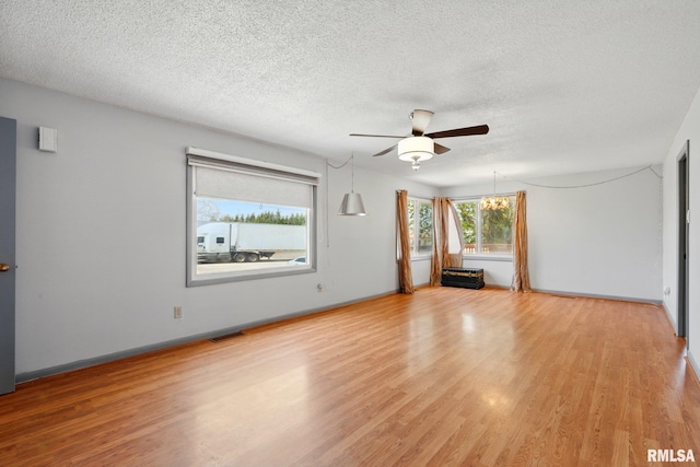 spare room with a textured ceiling, ceiling fan, visible vents, and light wood-style flooring