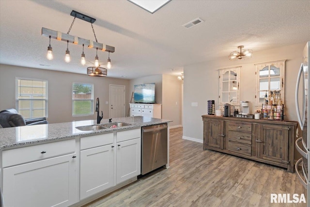 kitchen featuring visible vents, light wood-type flooring, a sink, white cabinets, and stainless steel appliances