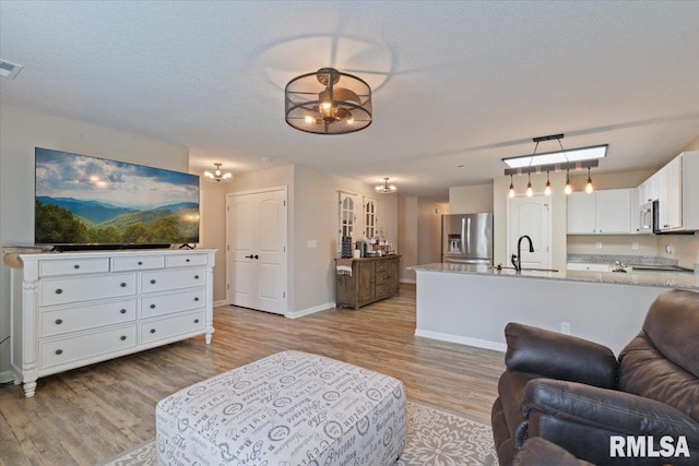 living room featuring baseboards, visible vents, and light wood-style floors