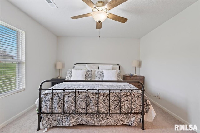 carpeted bedroom featuring visible vents, baseboards, and ceiling fan