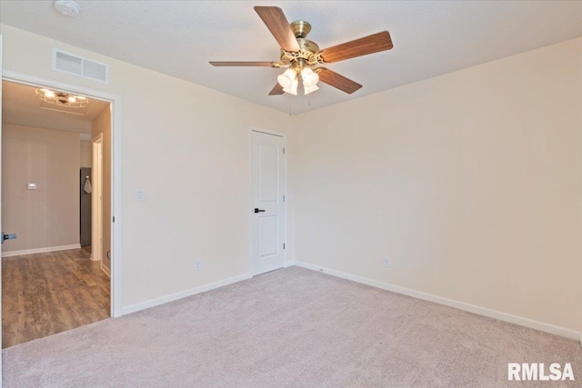 empty room featuring visible vents, carpet, baseboards, and a ceiling fan