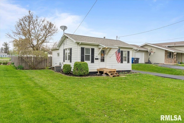 view of front facade with an attached garage, fence, and a front yard