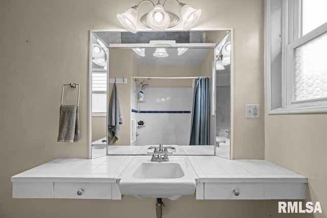 full bathroom with a sink, curtained shower, and a wealth of natural light