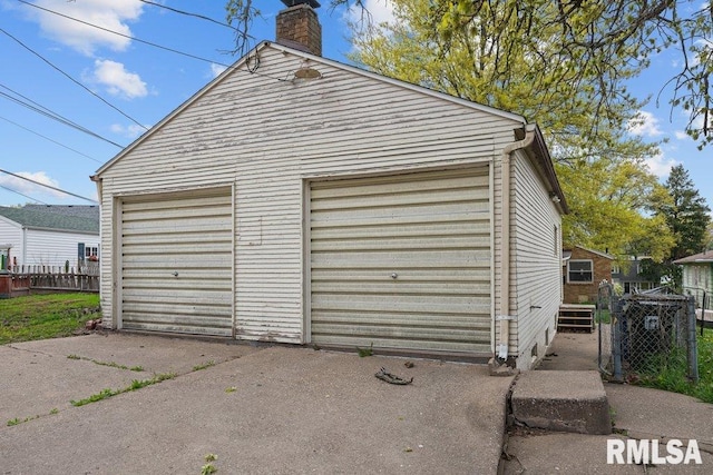 detached garage featuring fence