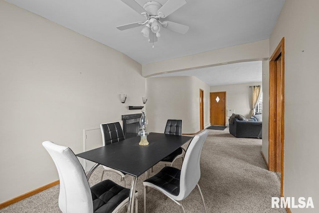 dining area with baseboards, ceiling fan, and carpet flooring