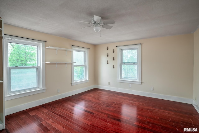 spare room featuring a textured ceiling, ceiling fan, a wealth of natural light, and hardwood / wood-style floors