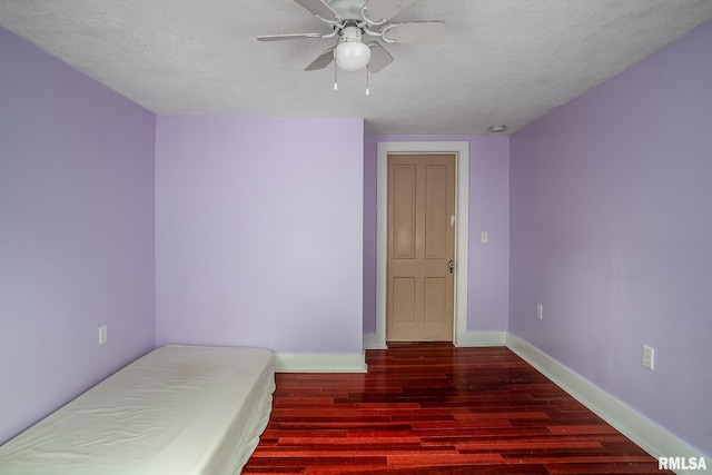 bedroom with ceiling fan, a textured ceiling, baseboards, and wood finished floors
