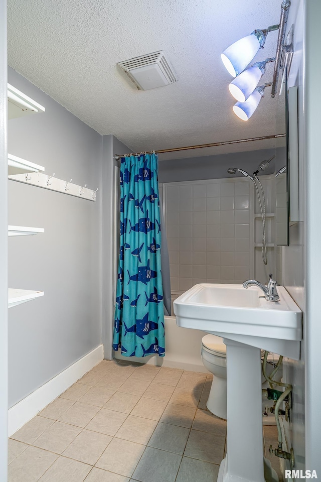 bathroom with tile patterned flooring, a textured ceiling, and visible vents