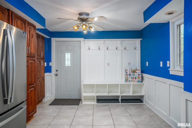 mudroom featuring a ceiling fan, wainscoting, and a decorative wall