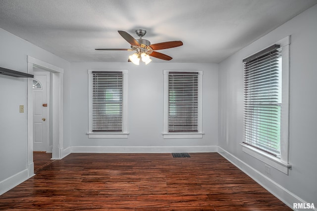 spare room featuring baseboards, ceiling fan, and a wealth of natural light