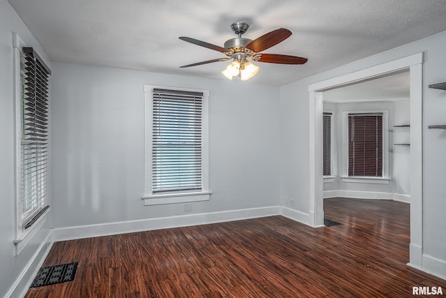 unfurnished room featuring visible vents, a ceiling fan, baseboards, and wood finished floors