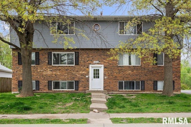 view of front of property with brick siding and a front yard