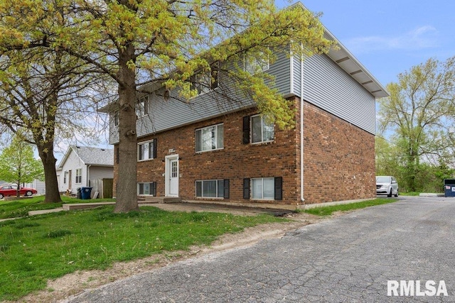 view of front of home featuring a front yard and brick siding