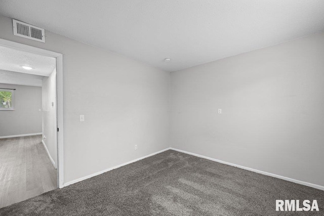 carpeted empty room with baseboards and visible vents